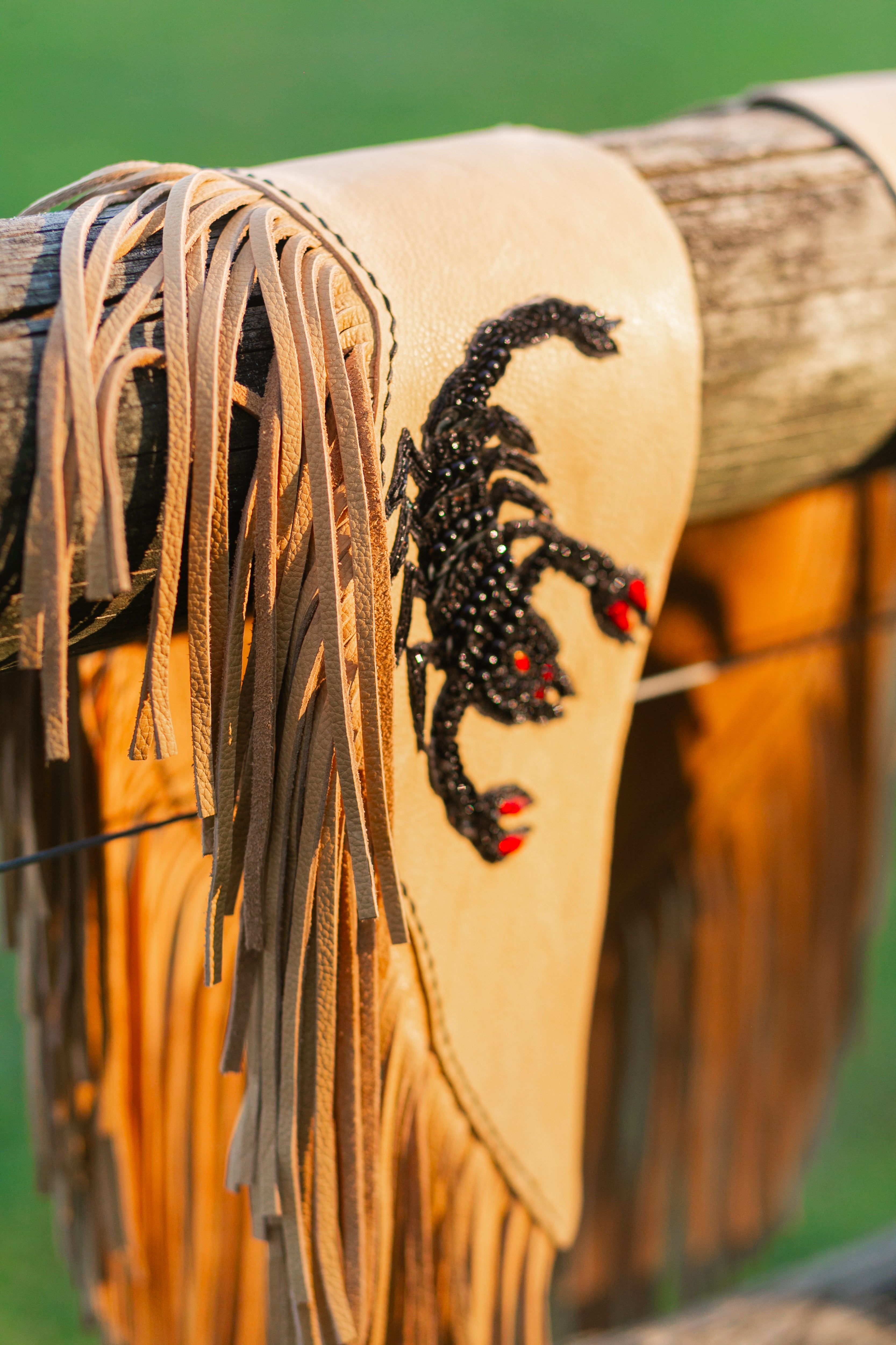 Decorative cape with a black and red pattern on a wooden fence